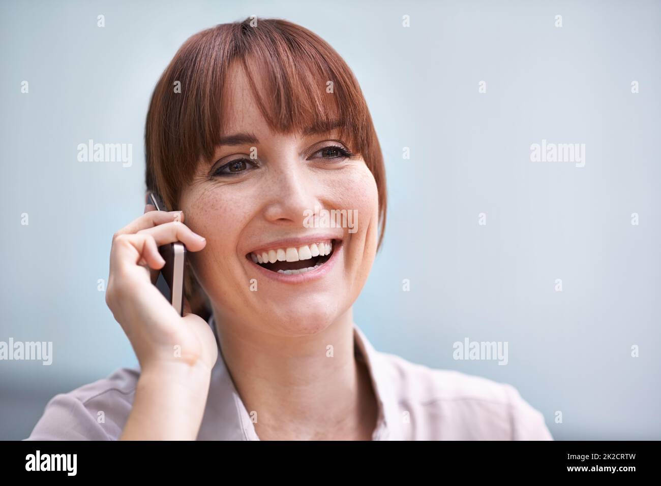 Mobile Positivität. Kopf- und Schulteraufnahme einer jungen Geschäftsfrau, die auf einem Handy spricht. Stockfoto