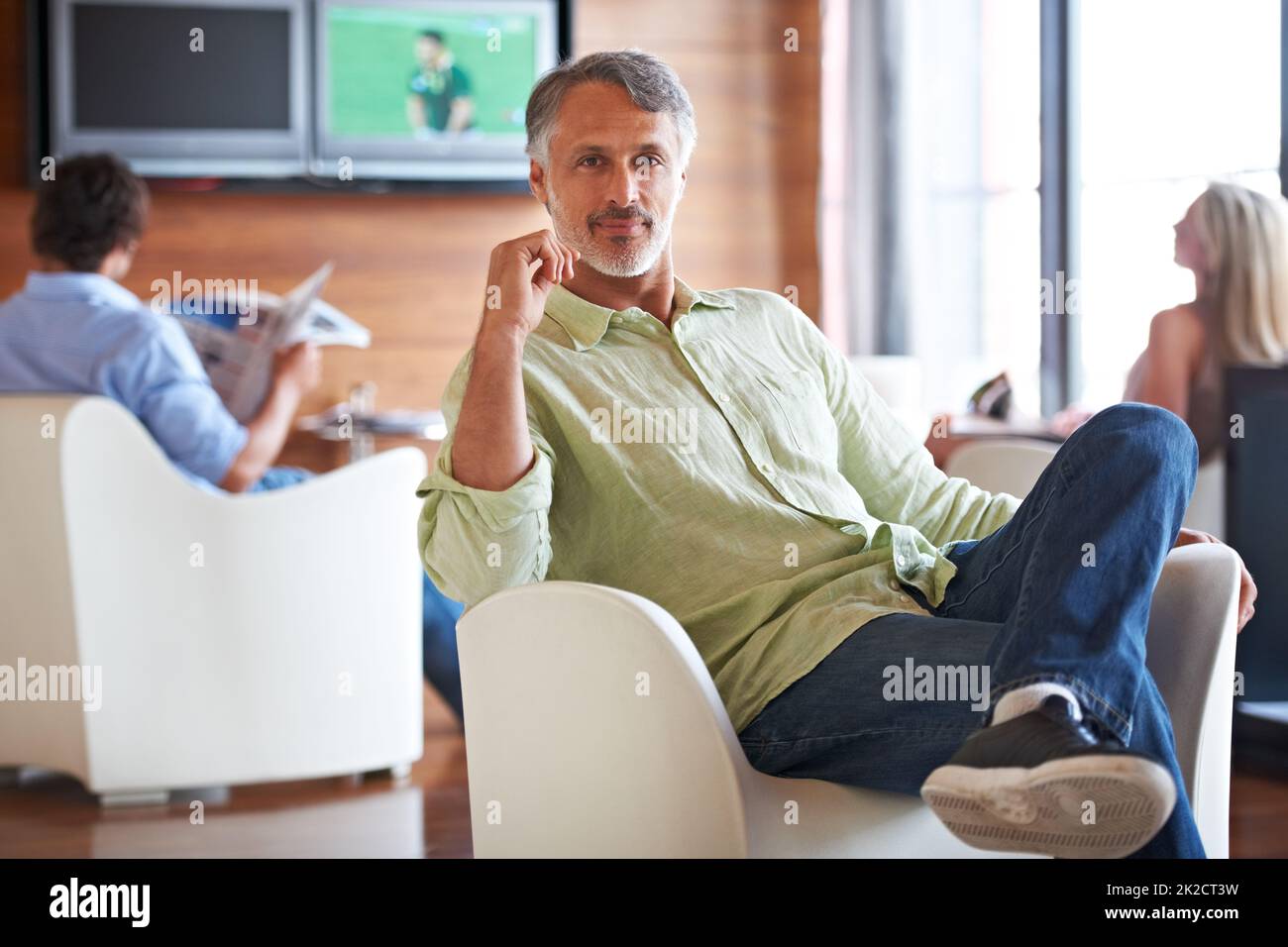 Jedes Büro braucht einen Ort zum Entspannen. Aufnahme eines Mannes, der in Innenräumen selbstbewusst auf einem Stuhl sitzt. Stockfoto