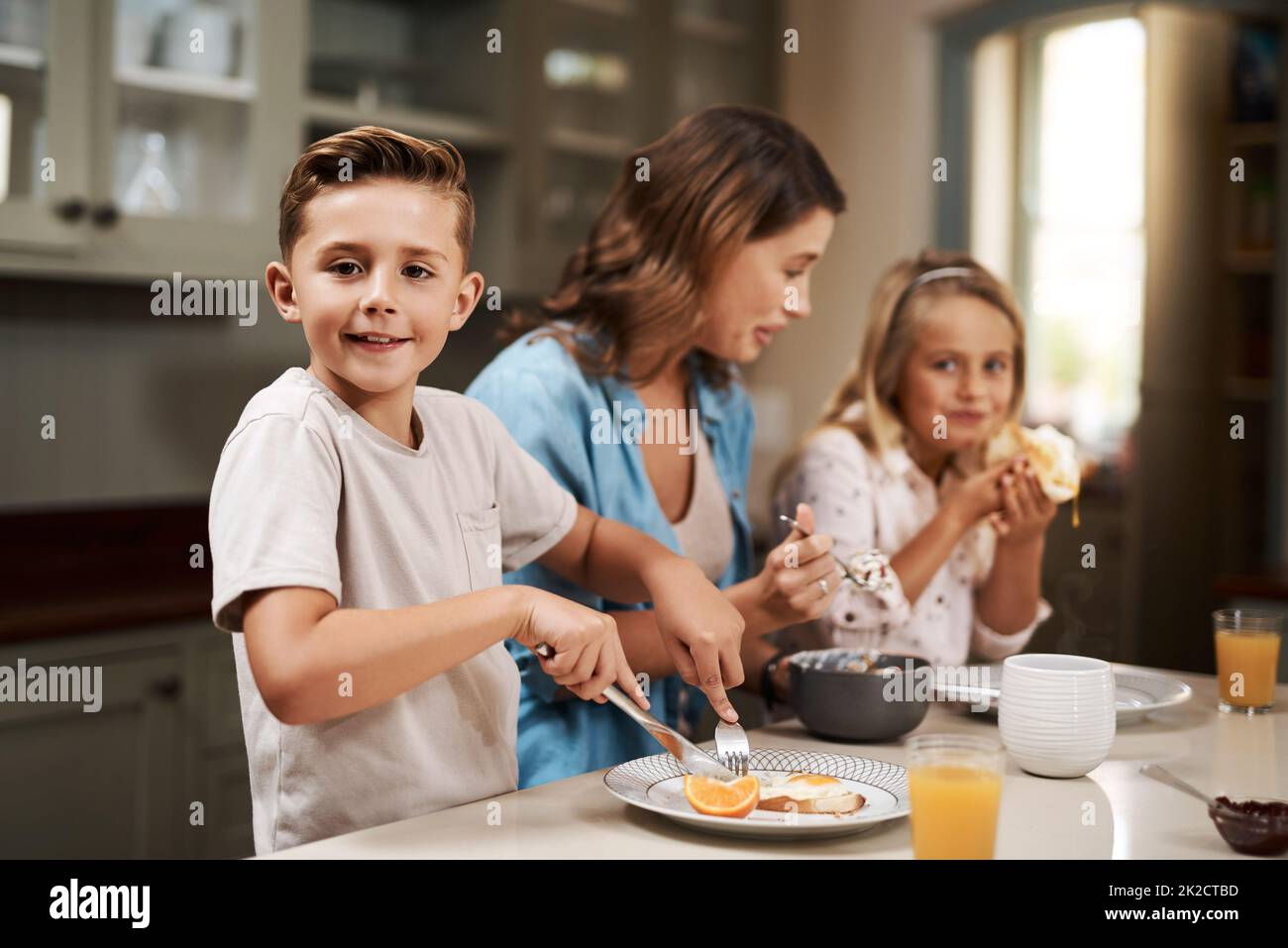 Es ist Frühstückszeit. Eine kleine Aufnahme einer jungen Familie, die zu Hause frühstückte. Stockfoto