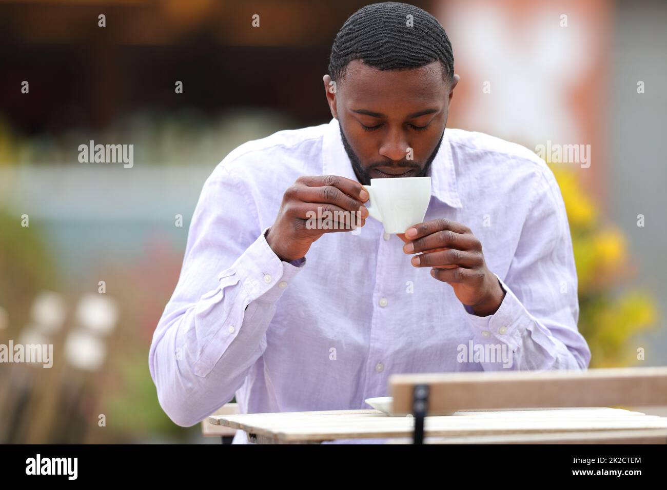 Ein Mann mit schwarzer Haut trinkt Kaffee in einer Bar Stockfoto
