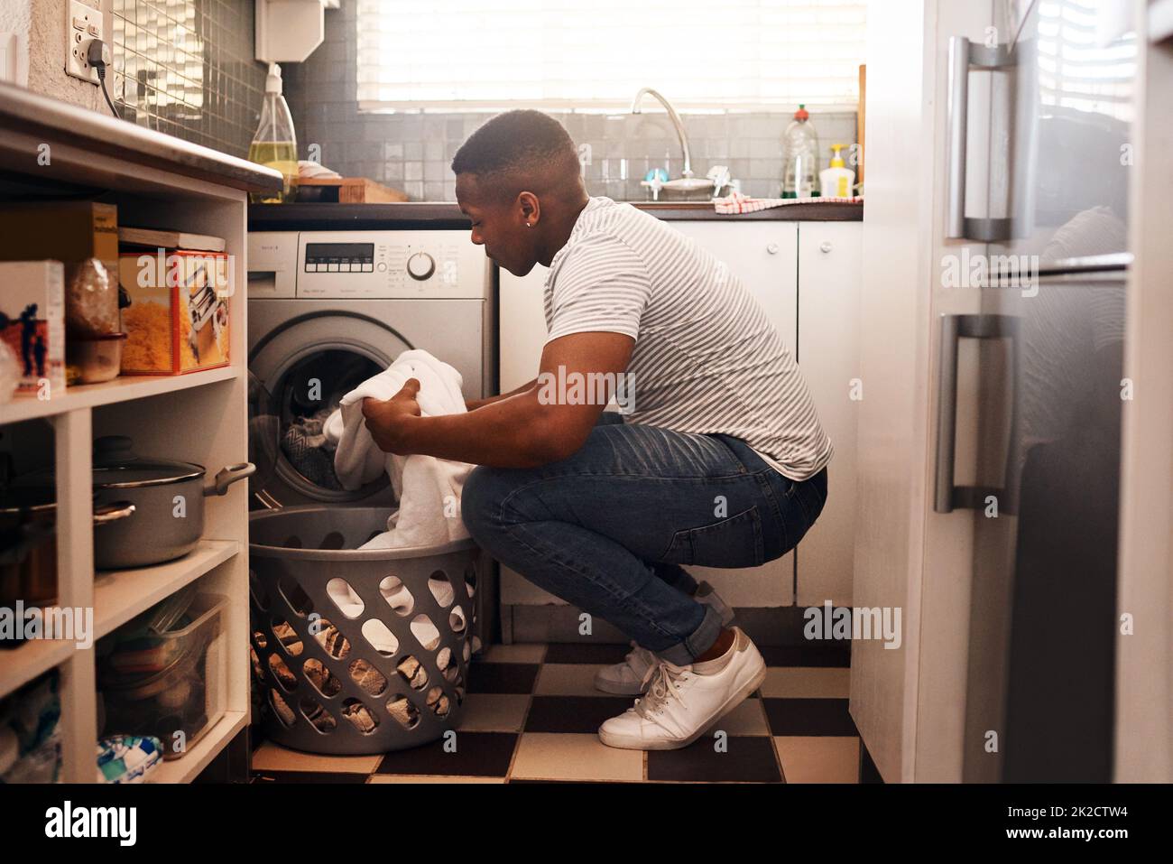 Ich mache am Wochenende immer Wäsche. Aufnahme eines Mannes, der die Wäsche zu Hause macht. Stockfoto