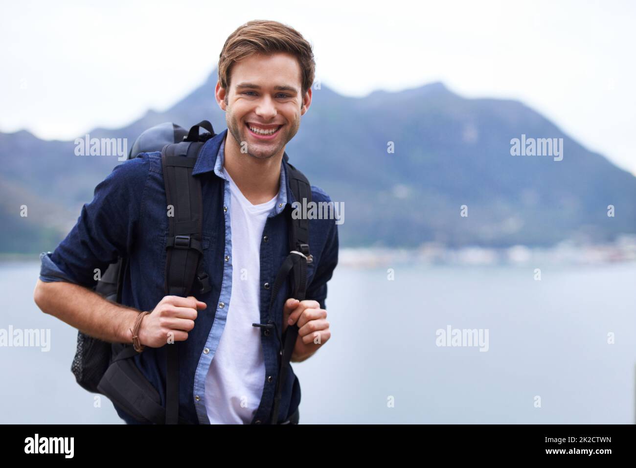 Bestes Wanderziel. Porträt eines hübschen jungen Mannes, der mit einem Rucksack im Freien steht. Stockfoto