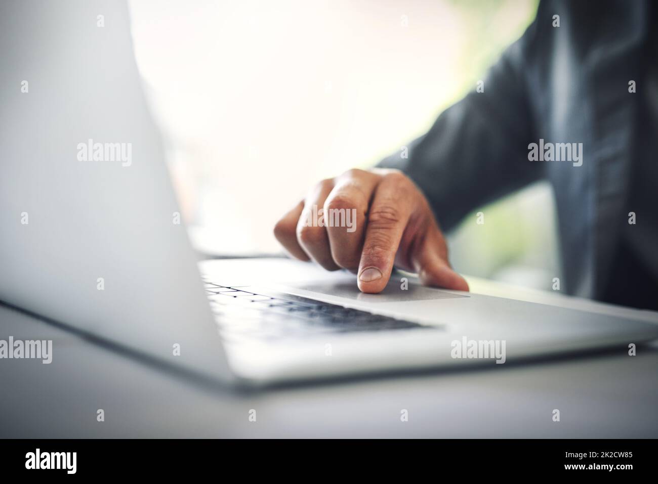 Er hat einen vertrauenswürdigen Laptop. Aufnahme eines unerkennbaren Geschäftsmannes, der tagsüber im Büro an seinem Laptop arbeitet. Stockfoto