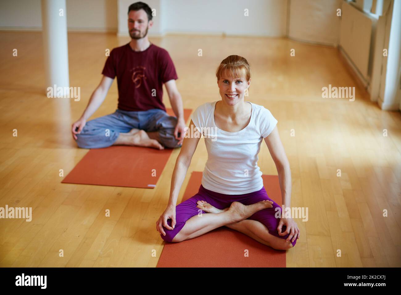 Das beste Workout nach einem anstrengenden Tag. Aufnahme von zwei Menschen, die gemeinsam Yoga in Innenräumen machen. Stockfoto