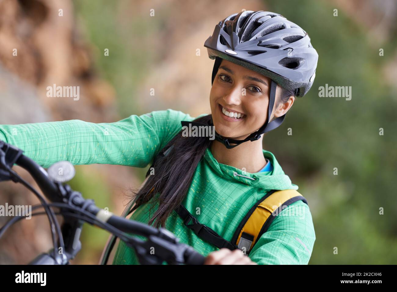 Mountainbiken ist billiger als das Fitnessstudio und hat eine viel bessere Aussicht. Eine reizende junge Frau, die mit dem Mountainbike in einer malerischen Umgebung unterwegs ist. Stockfoto