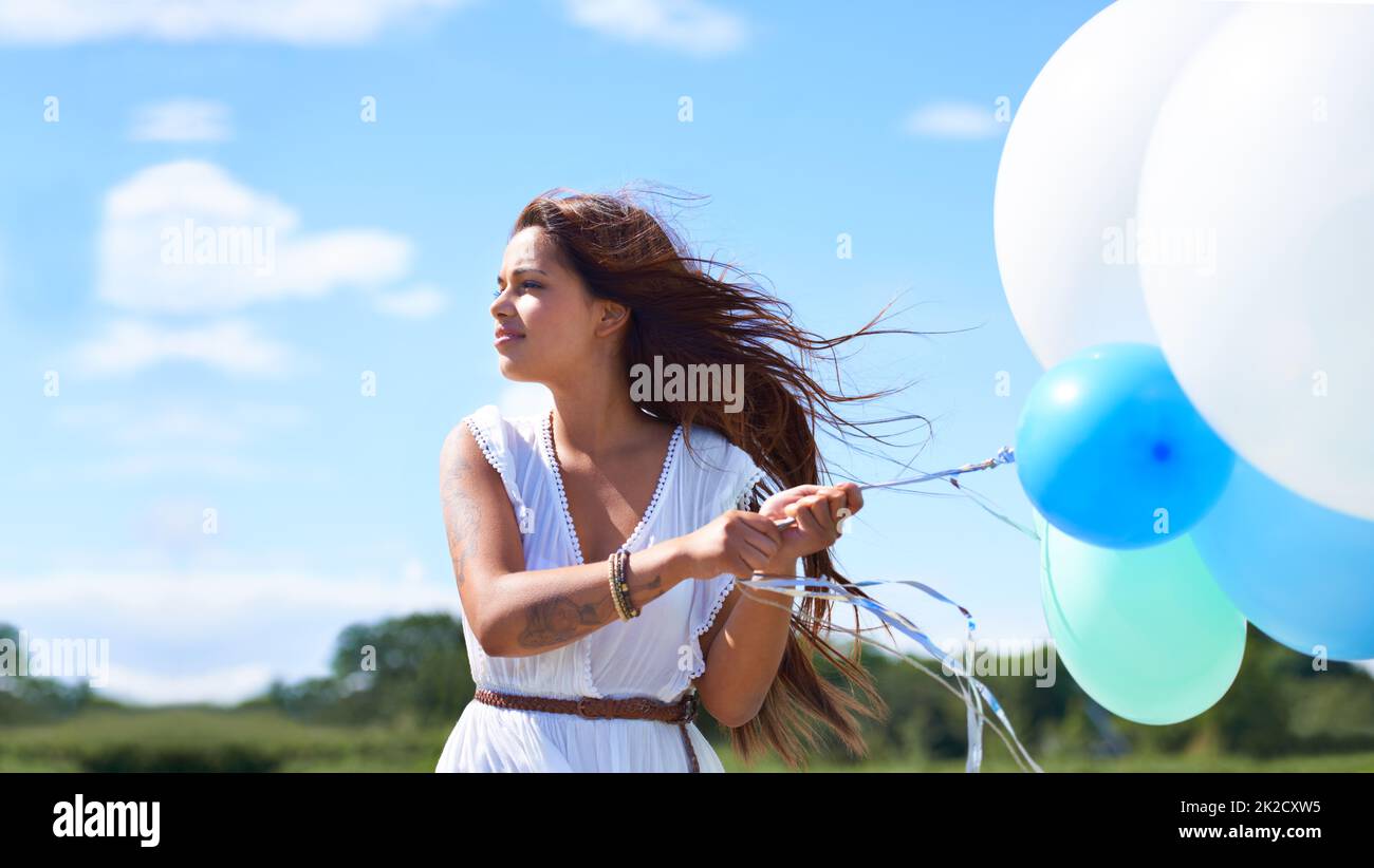 Genießen Sie den Tag mit ihren Ballonen. Kurzer Schuss einer wunderschönen tätowierten jungen Frau, die Ballons hält. Stockfoto