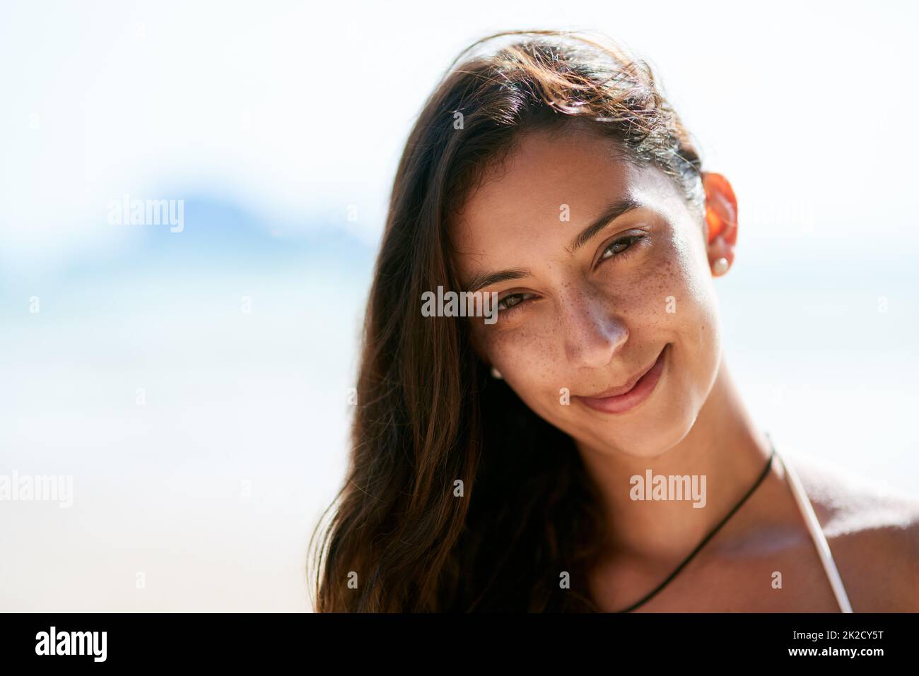 Sommersprossen sind wild. Nahaufnahme einer schönen jungen Frau, die am Strand posiert. Stockfoto