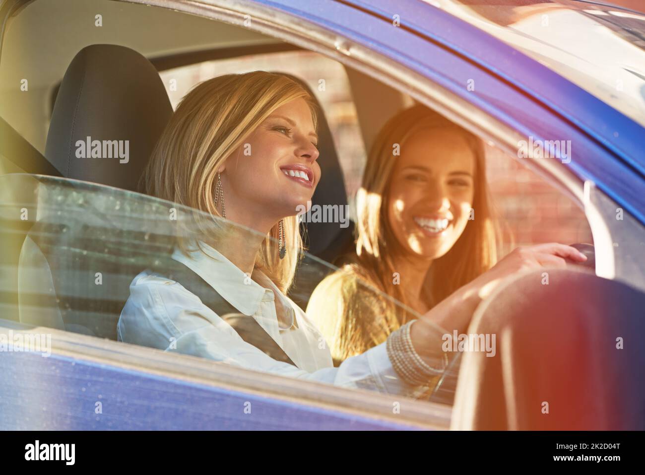 Auf dem Weg zum Einkaufszentrum. Aufnahme von zwei jungen Frauen, die in einem Auto in der Stadt unterwegs sind. Stockfoto