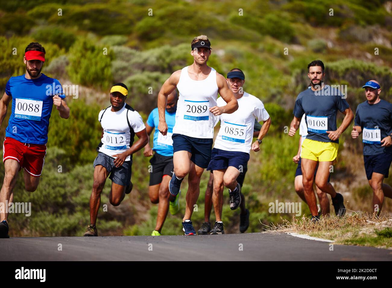 Das Tempo bestimmen. Aufnahme einer Gruppe junger Männer, die einen Marathon laufen. Stockfoto