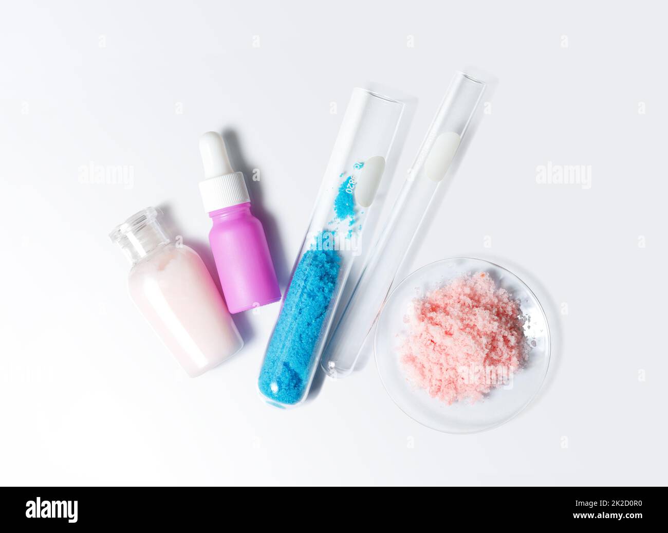Pflegecreme, Serum, Kupfer(II)-Sulfat im Reagenzglas und himalaya-Rosa-Salz. Chemikalien für die Schönheitspflege auf weißem Labortisch. (Draufsicht) Stockfoto