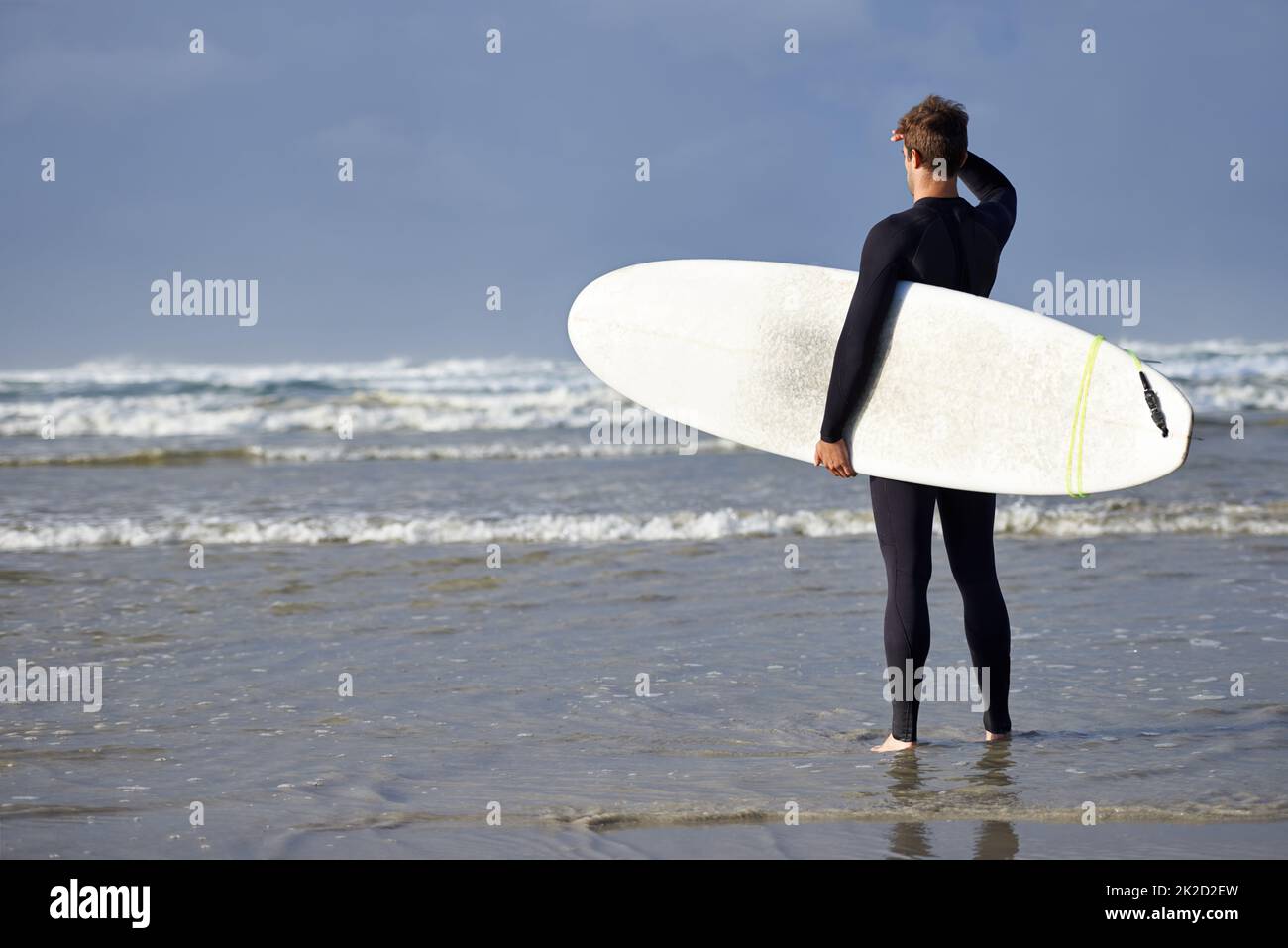 Bereit für die Wellen. Aufnahme eines jungen Mannes, der kurz vor dem Surfen steht. Stockfoto