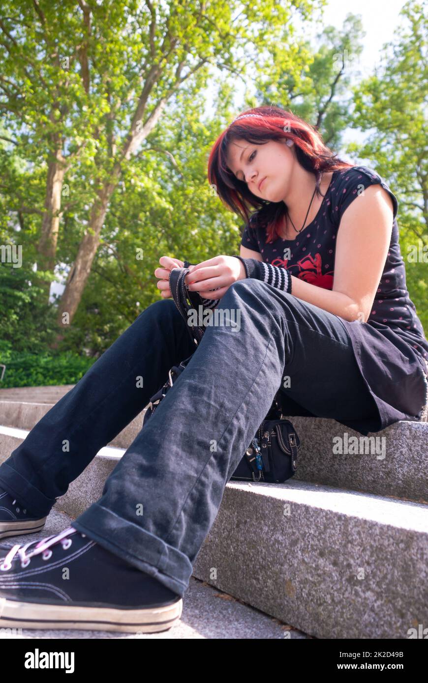 Punk-Emo-Mädchen, junger Erwachsener mit schwarzem rotem Haar Stockfoto