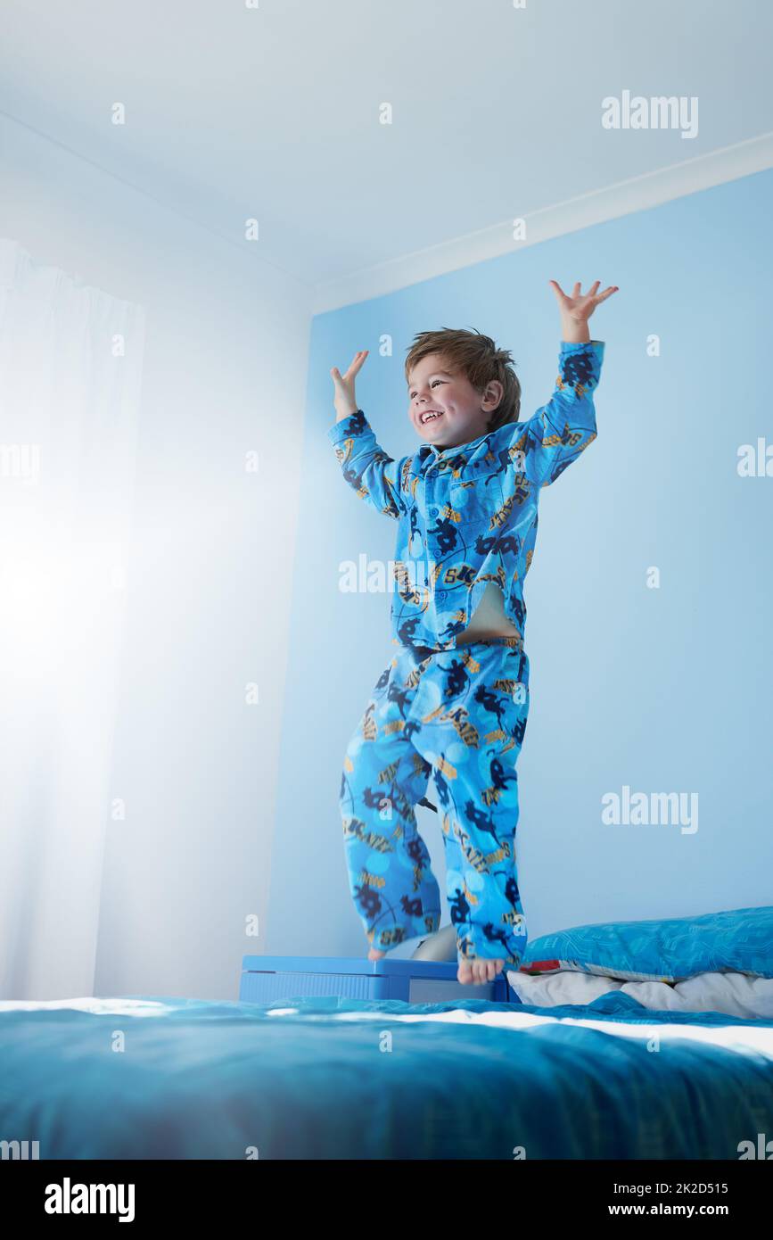 HES bekam endlose Energie. Aufnahme eines kleinen Jungen, der auf seinem Bett springt. Stockfoto