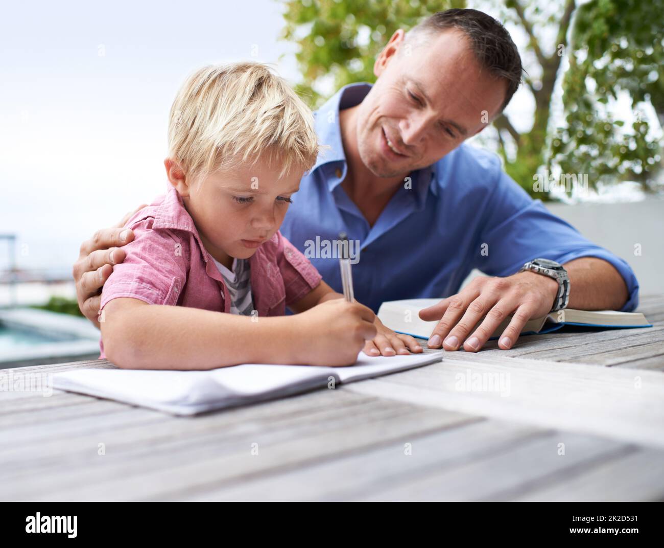 Papa hilft mir, meinen Geist zu erweitern. Aufnahme eines Vaters, der seinem Sohn mit seinem Malbuch half. Stockfoto