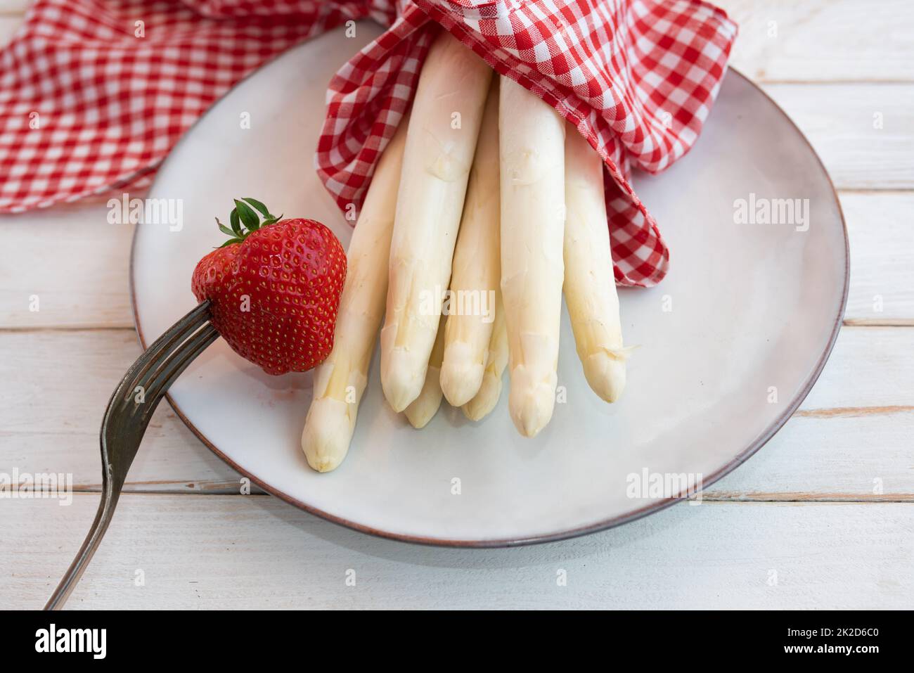 Teller mit frischem weißem Spargel und Erdbeere Stockfoto