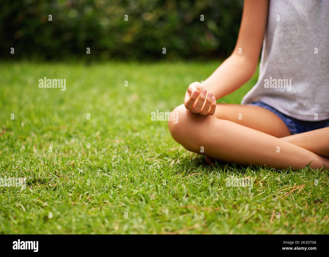 Sie liebt es einfach, draußen zu sein. Ausgeschnittene Aufnahme einer jungen Frau, die im Garten meditiert. Stockfoto