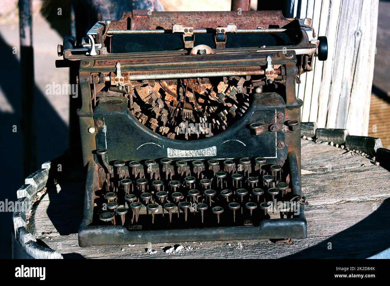 Antike rostige Schreibmaschine auf einem Holzfass Stockfoto