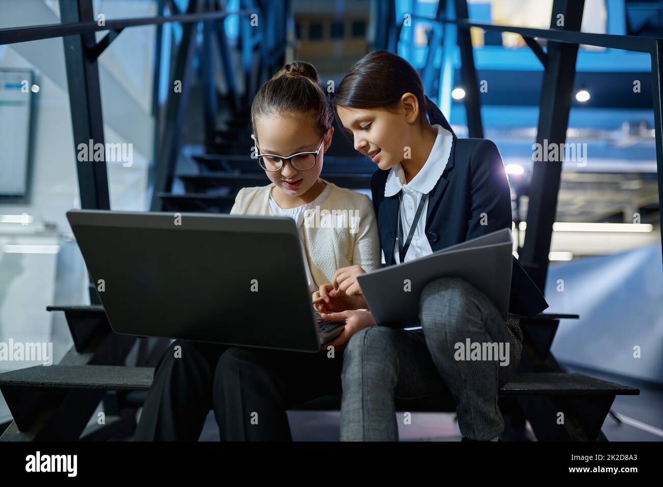 Zwei Geschäftskinder, die zusammen auf Treppen arbeiten Stockfoto