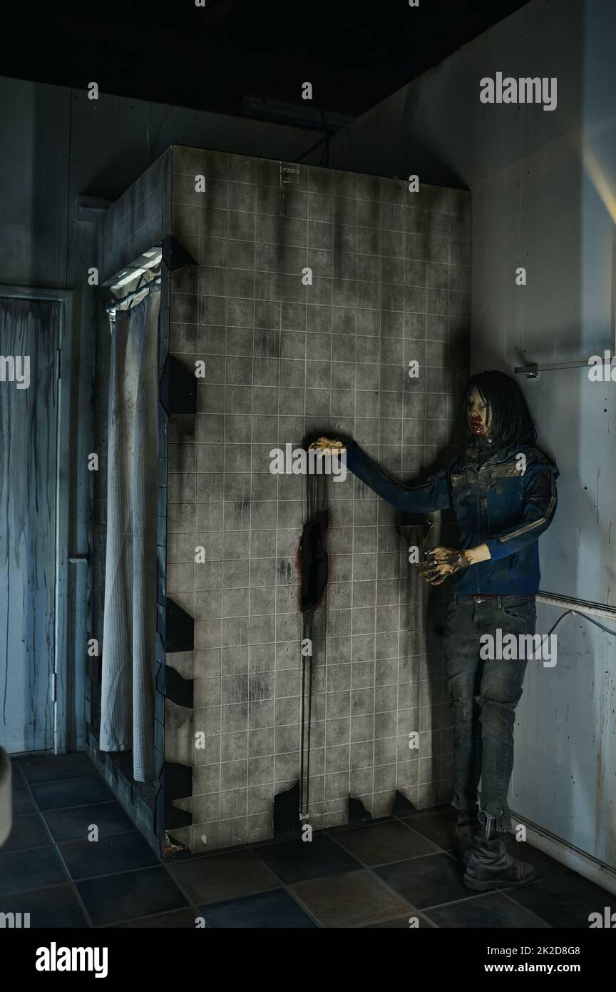 Blutbefleckter gruseliger Zombie, der hinter der Duschkabine steht Stockfoto
