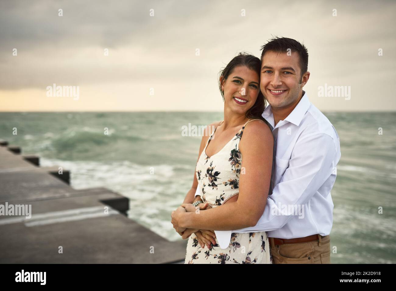 Shes meine eine und einzige. Beschnittenes Porträt eines liebevollen jungen Paares, das auf dem Steg am Strand steht. Stockfoto