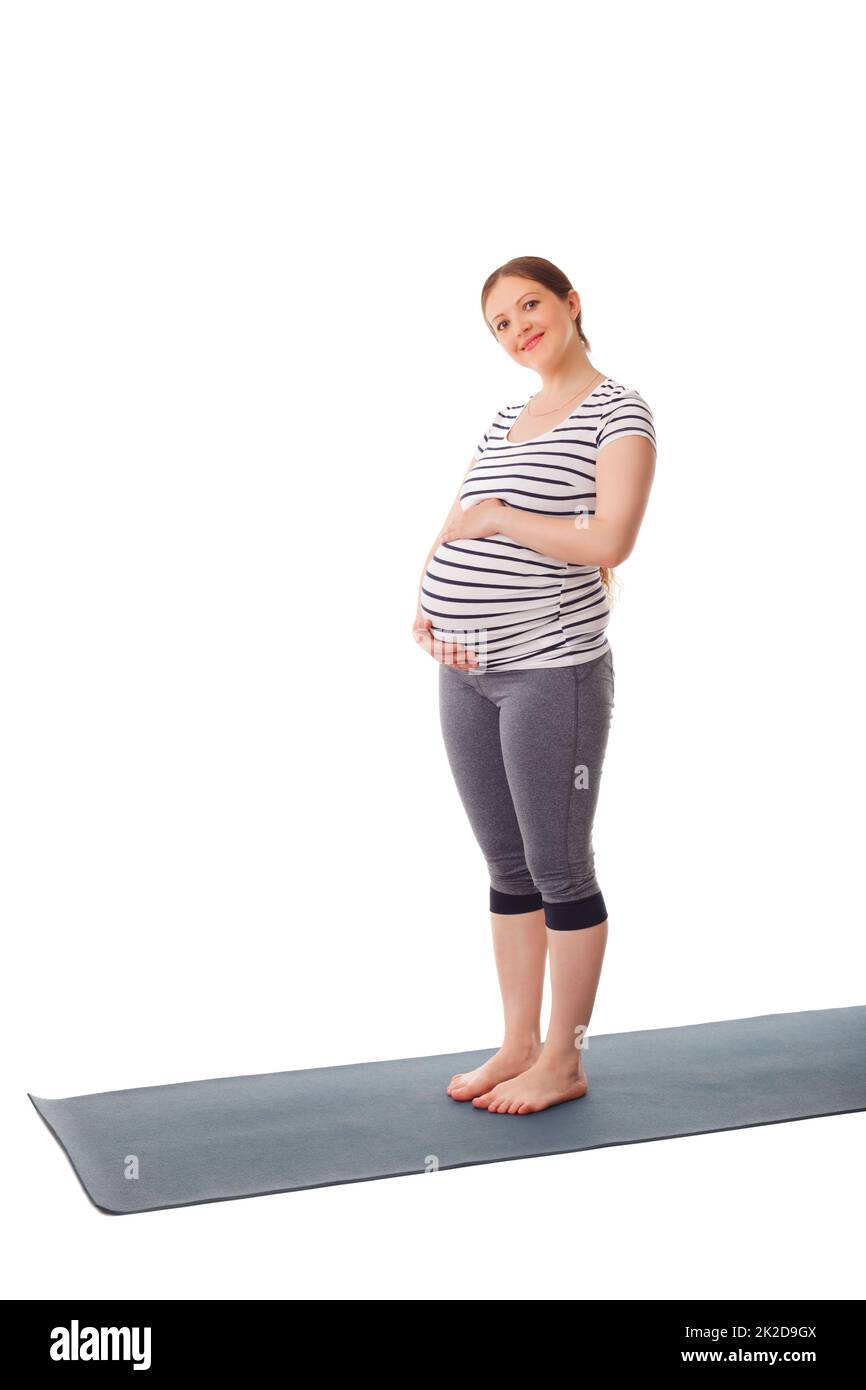 Eine Schwangerin steht und umarmt ihren Bauch Stockfoto