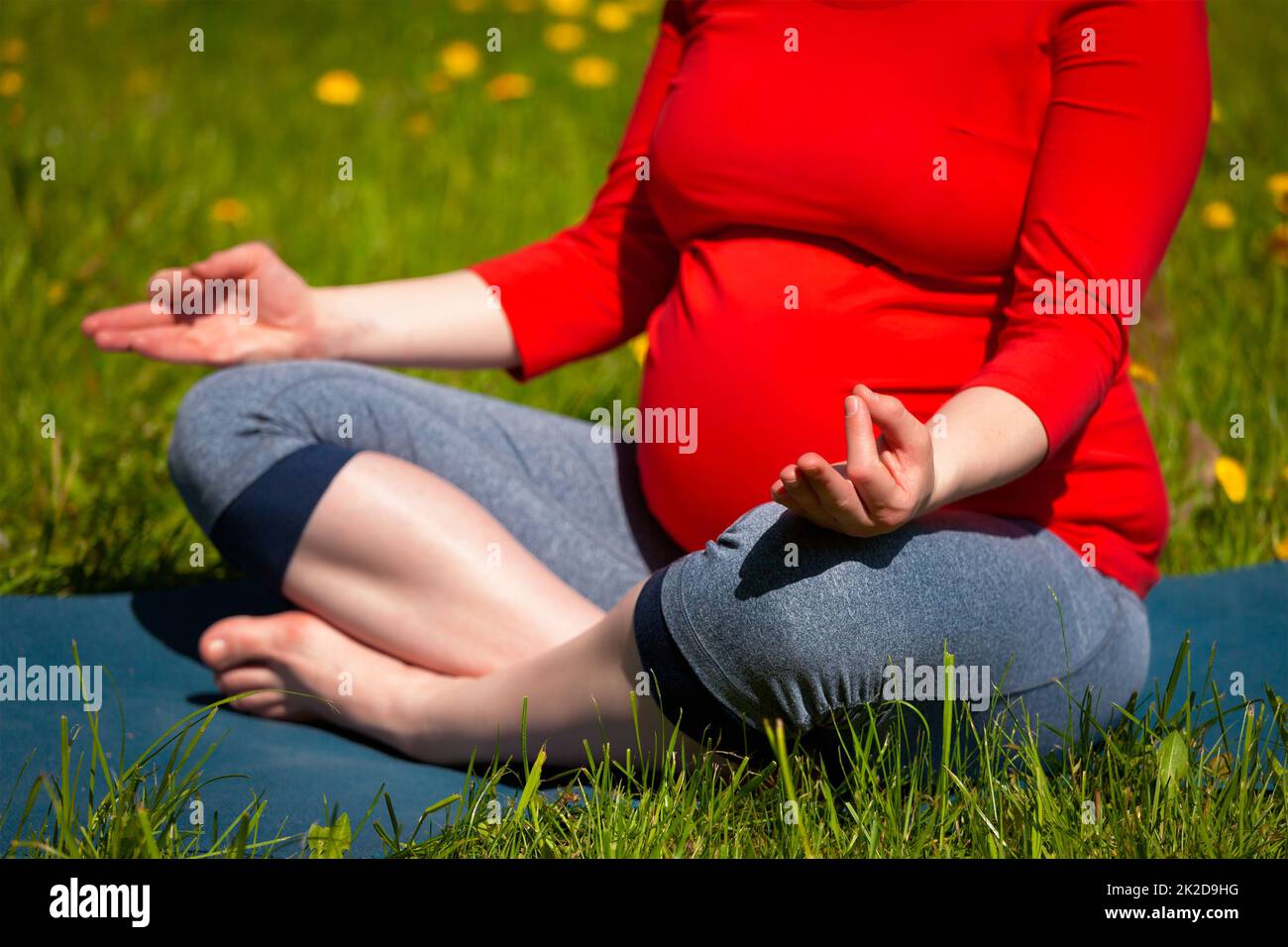 Schwangere, die im Freien Asana Sukhasana macht Stockfoto