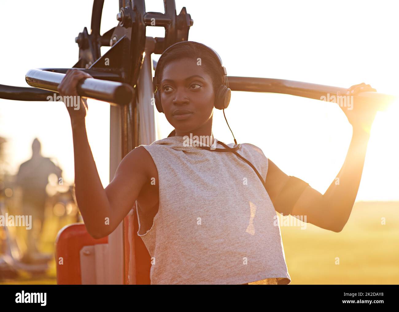 Bleiben Sie fit und stark. Eine junge Frau, die im Park Trainingsgeräte im Freien nutzt. Stockfoto