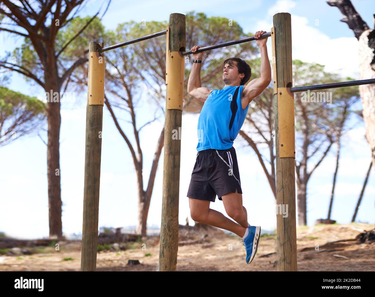 Entschlossenheit ist alles. Junger erwachsener Mann, der Fitnessgeräte im Freien nutzt. Stockfoto