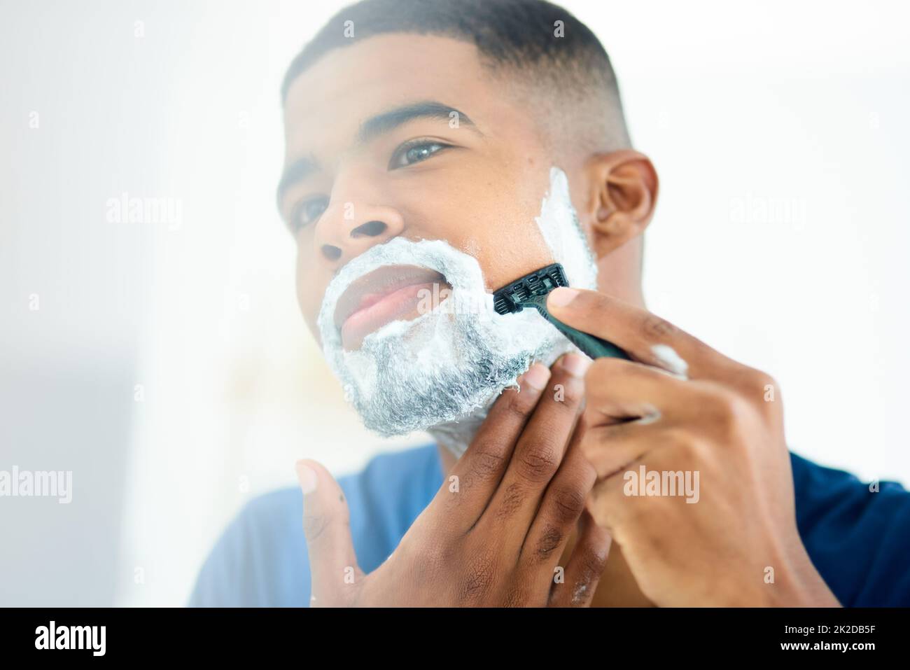 Bin heute Morgen in der Stimmung aufgewacht, sich zu rasieren. Aufnahme eines jungen Mannes, der sich fokussiert, während er sein Gesicht rasiert. Stockfoto
