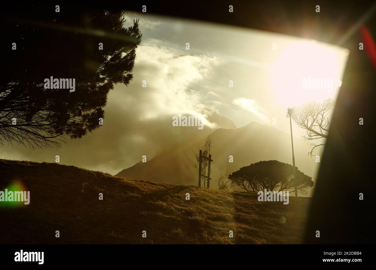 Die Schönheit der Natur. Ein Sonnenuntergang hinter bewölkten Bergen. Stockfoto