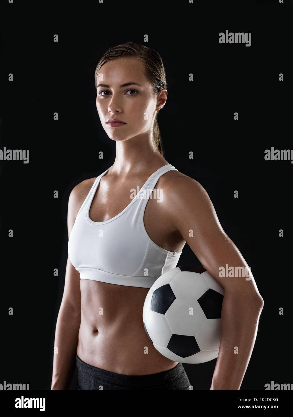 Bereit, den Ball ins Rollen zu bringen. Porträt einer athletischen jungen Frau, die bereit ist, ein Fußballspiel zu spielen. Stockfoto
