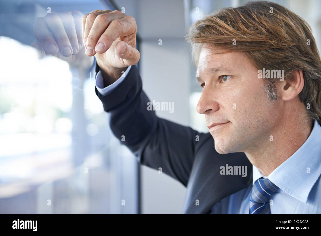 Über seine Zukunft nachdenken. Aufnahme eines reifen Geschäftsmannes in einem Bürogebäude. Stockfoto