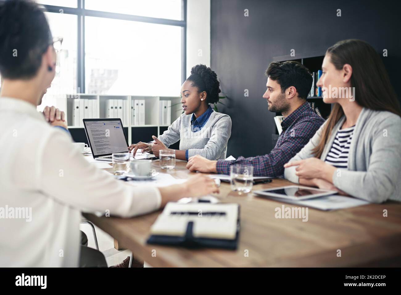 Teilen Sie ihre Ergebnisse mit anderen. Eine Aufnahme einer Gruppe von Geschäftsleuten, die sich im Sitzungssaal treffen. Stockfoto