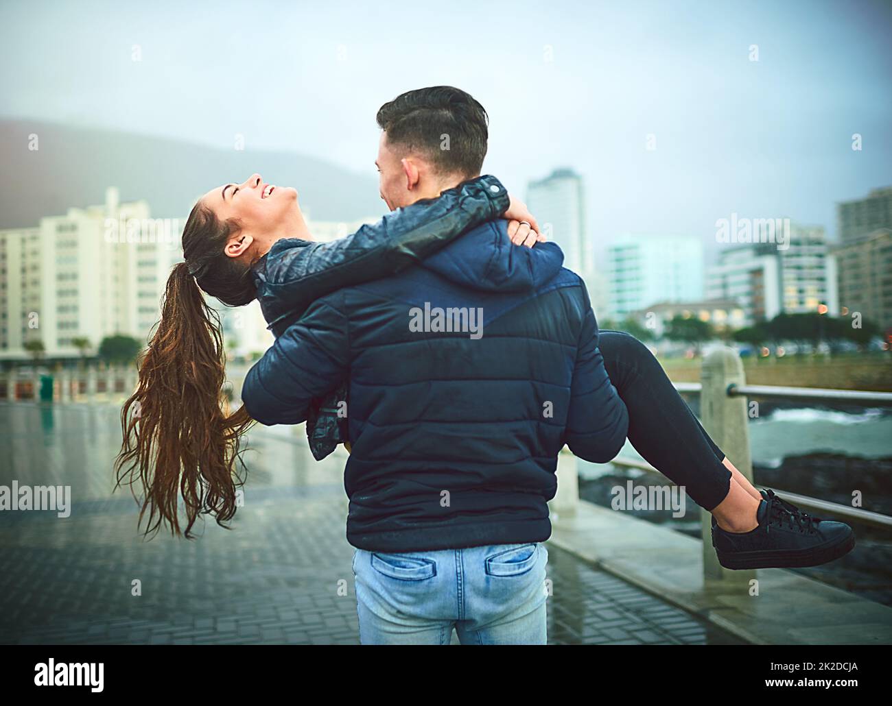 Lass dich von der Liebe forttragen. Aufnahme eines jungen Mannes, der seine Freundin romantisch im Freien trägt. Stockfoto