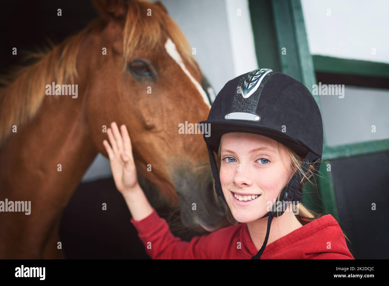Mein glücklicher Platz ist in den Ställen. Aufnahme eines Teenagers, das sich mit ihrem Pferd anklebte. Stockfoto
