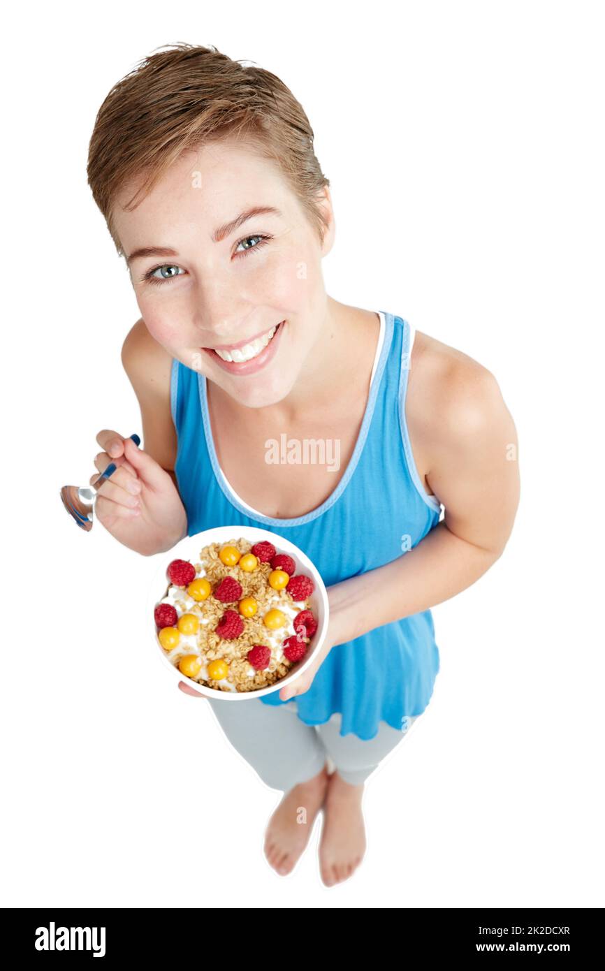 Gesund essen und glücklich sein. Studioporträt einer jungen Frau, die ein Müsli und Joghurt genießt. Stockfoto