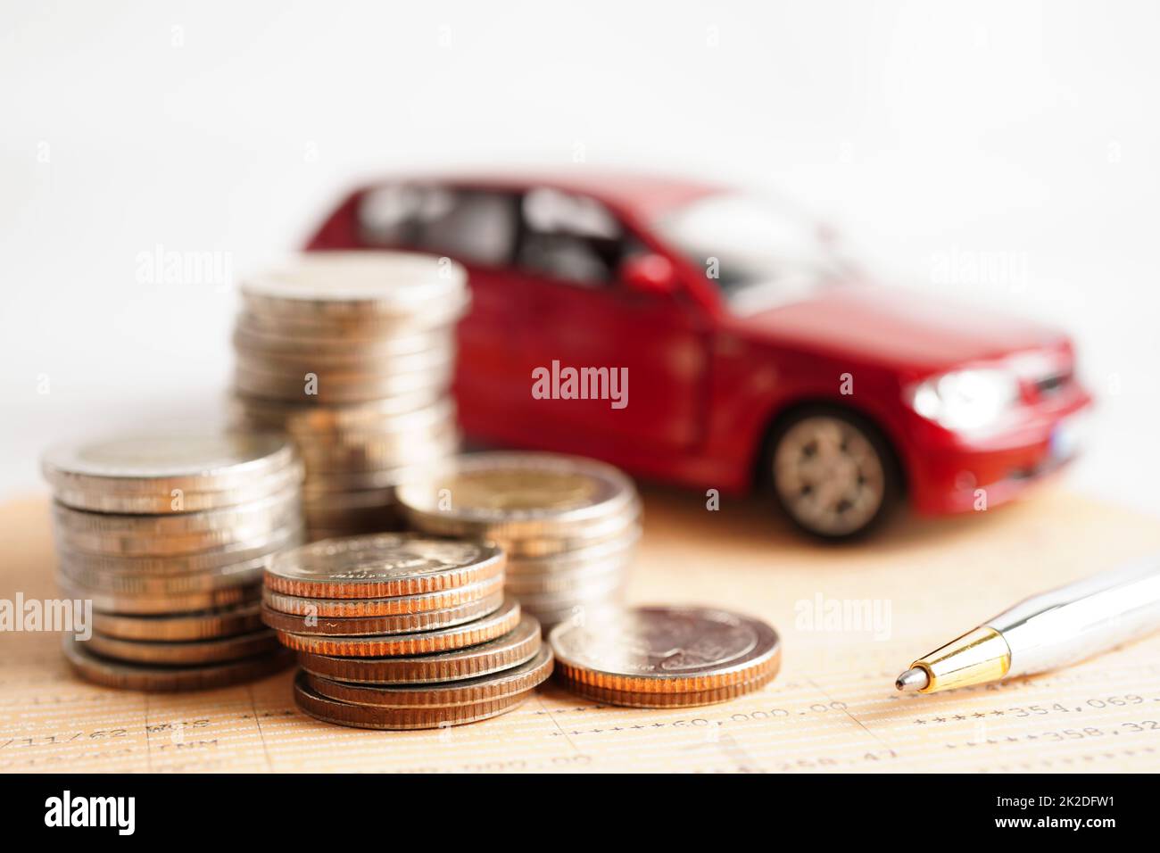 Auto auf Münzen Geld, Sparkasse, Finanzierung, Ratenzahlung, Autokredit Zinsen. Stockfoto