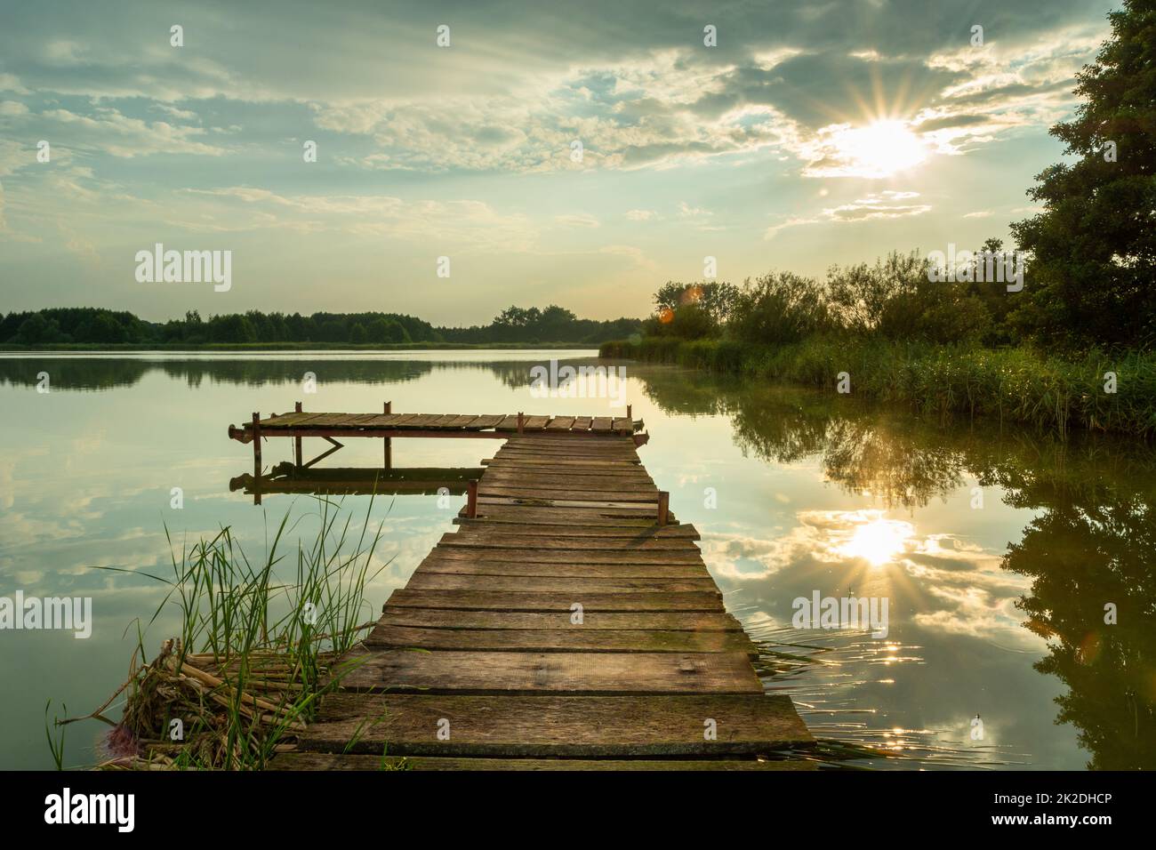 Sonnenlicht reflektiert auf dem See mit einem Pier Stockfoto