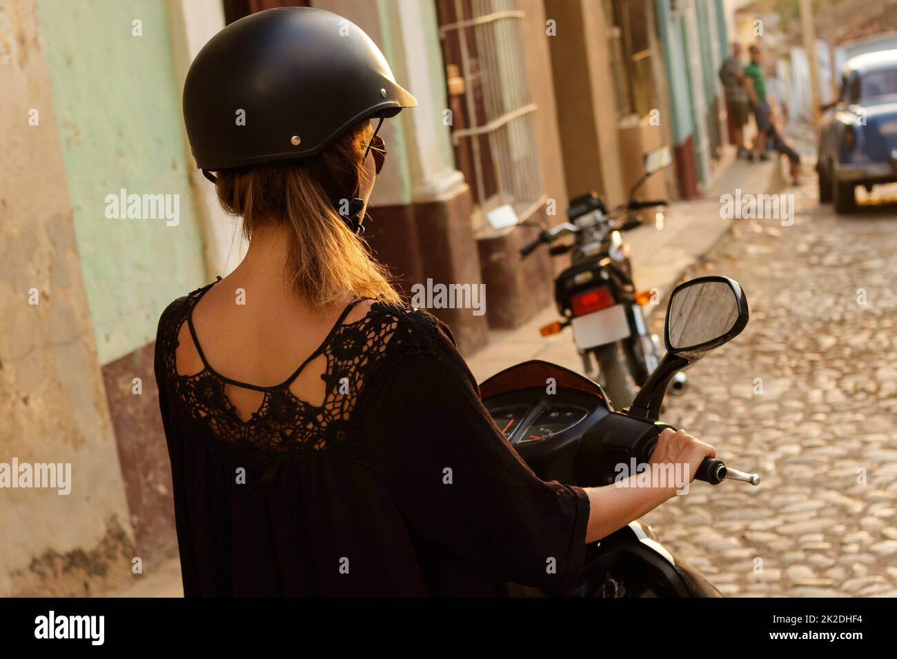 Frau fährt Roller durch die Straßen der Altstadt Stockfoto