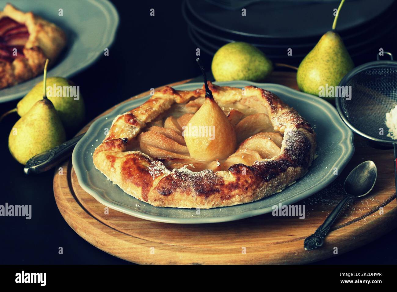 Hausgemachte Galette mit Birnen auf dunklem Hintergrund. Süßer offener Obstkuchen. Herbstbäckerei. Draufsicht Stockfoto