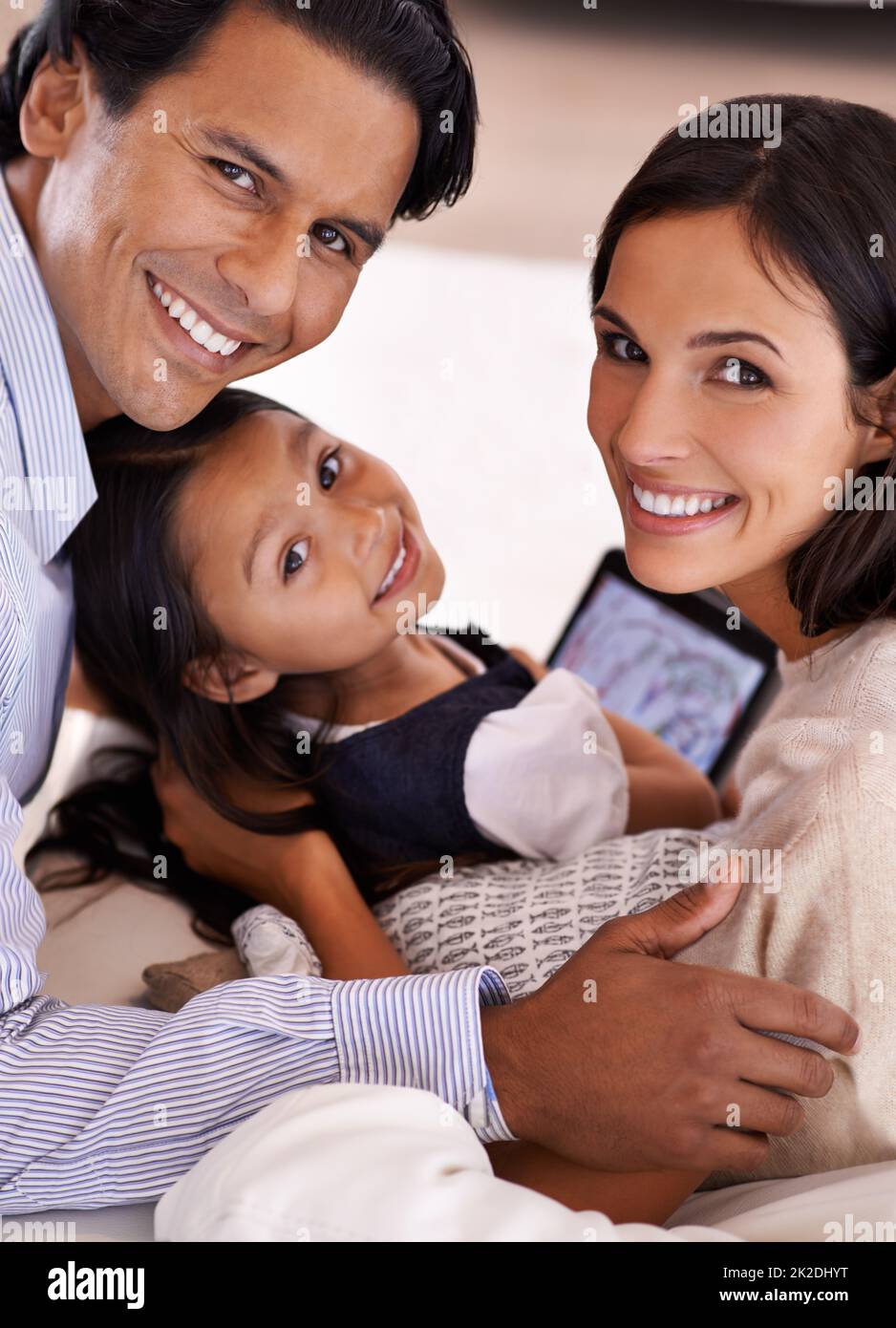 Zeit mit der Familie. Beschnittenes Porträt einer liebevollen jungen Familie, die ein digitales Tablet teilt. Stockfoto