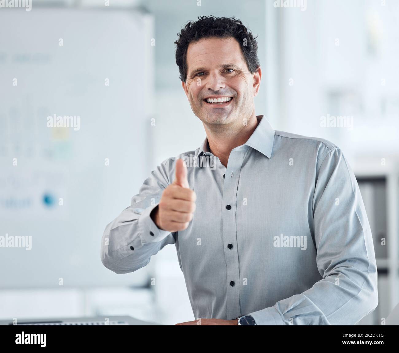 Porträt eines glücklichen Geschäftsmanns mit Daumen nach oben oder einem Lächeln für gute Arbeit und herzlichen Glückwunsch zum Erfolg der Arbeitsförderung. Ja oder Motivation durch Marketing oder Stockfoto