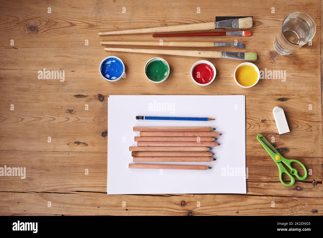 Kreativität ist ansteckend. Leeres Papier mit Malutensilien auf einem Holztisch. Stockfoto