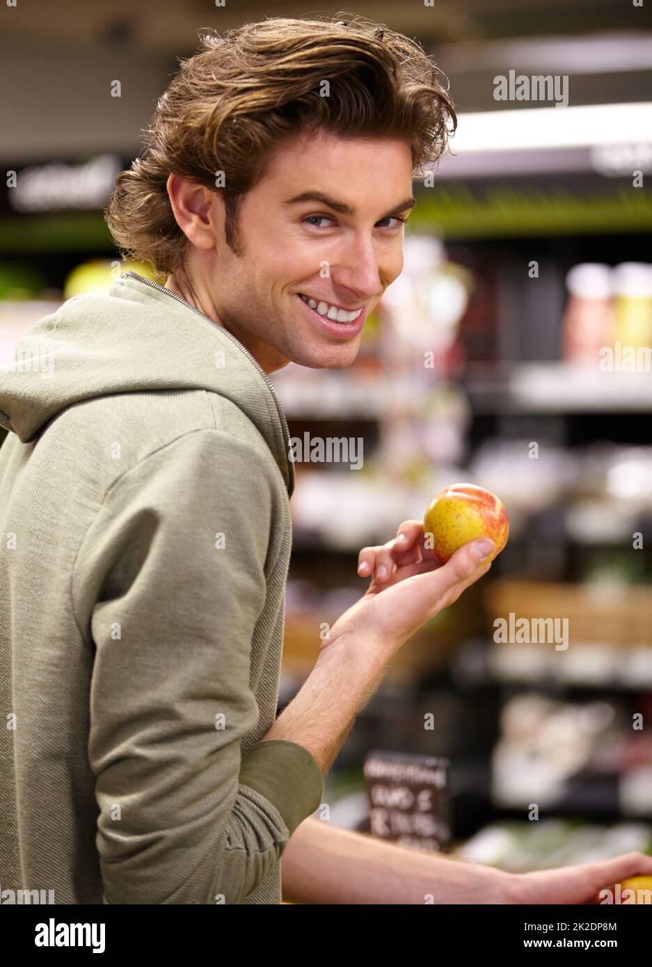 Ich will dieses hier. Ein junger Mann im Laden, der Obst kauft. Stockfoto
