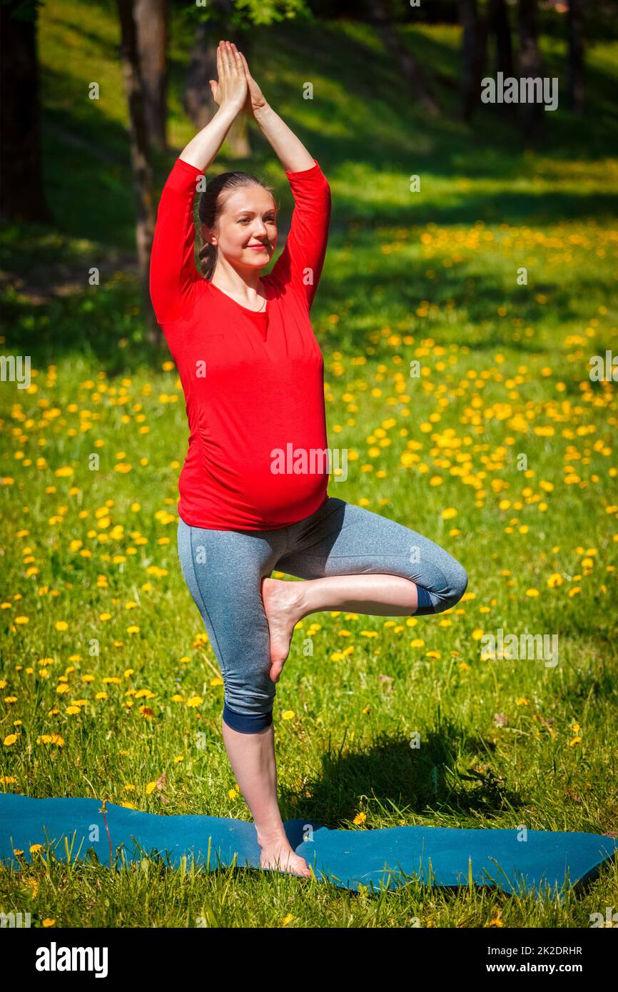 Schwanger Frau tun Asana vrikshasana im Freien Stockfoto