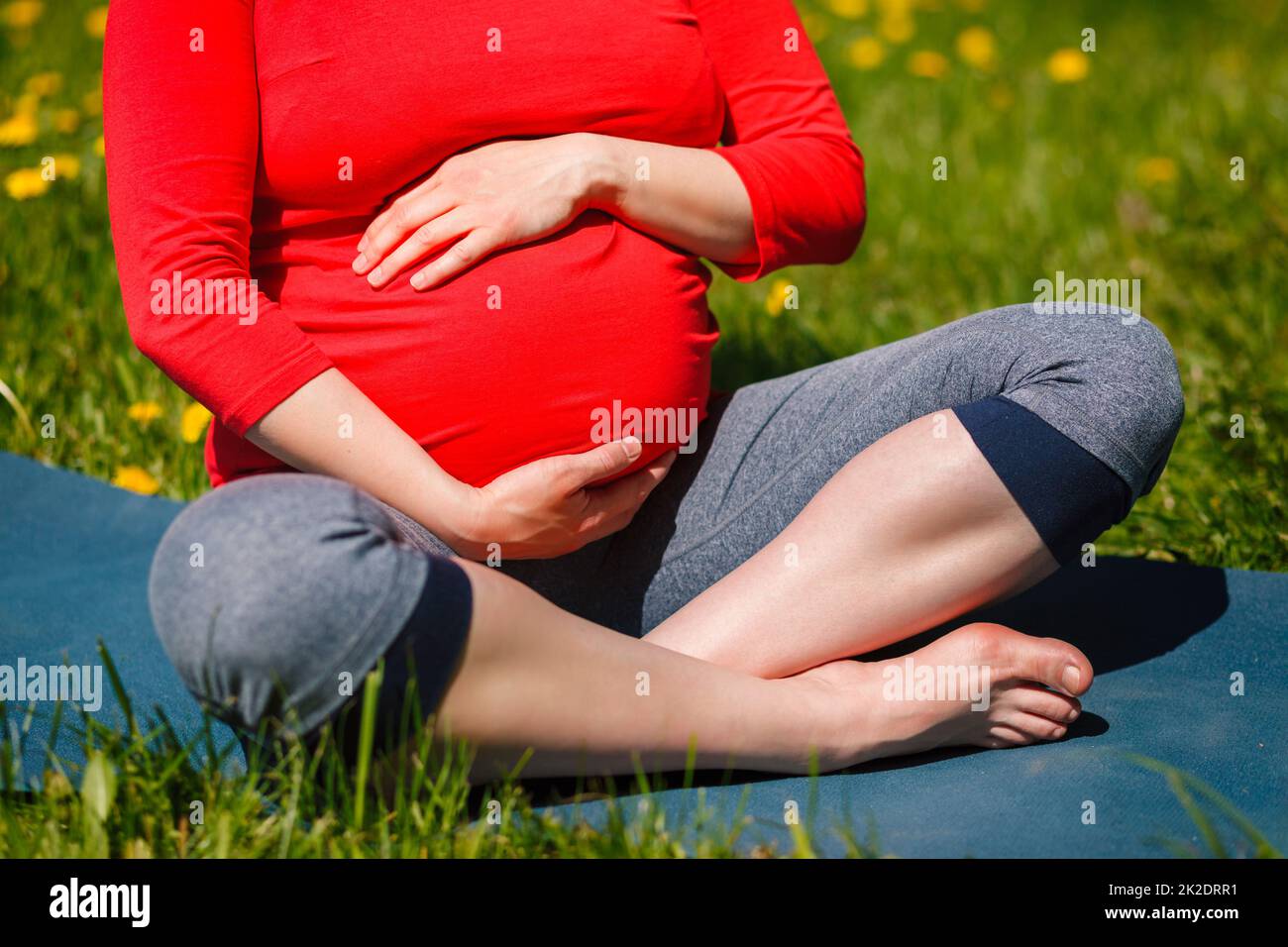 Schwangere, die im Freien Asana Sukhasana macht Stockfoto