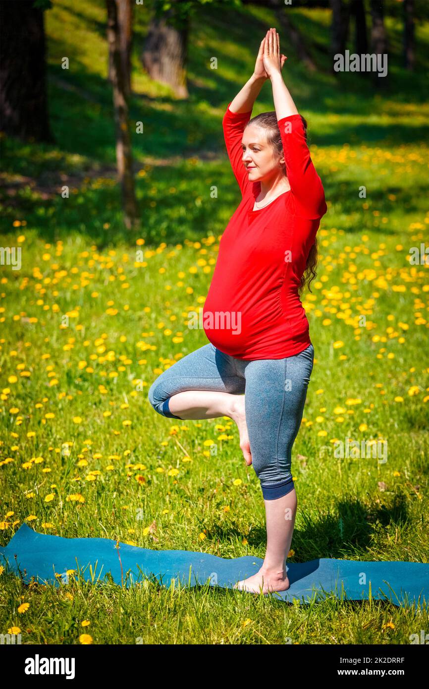Schwanger Frau tun Asana vrikshasana im Freien Stockfoto