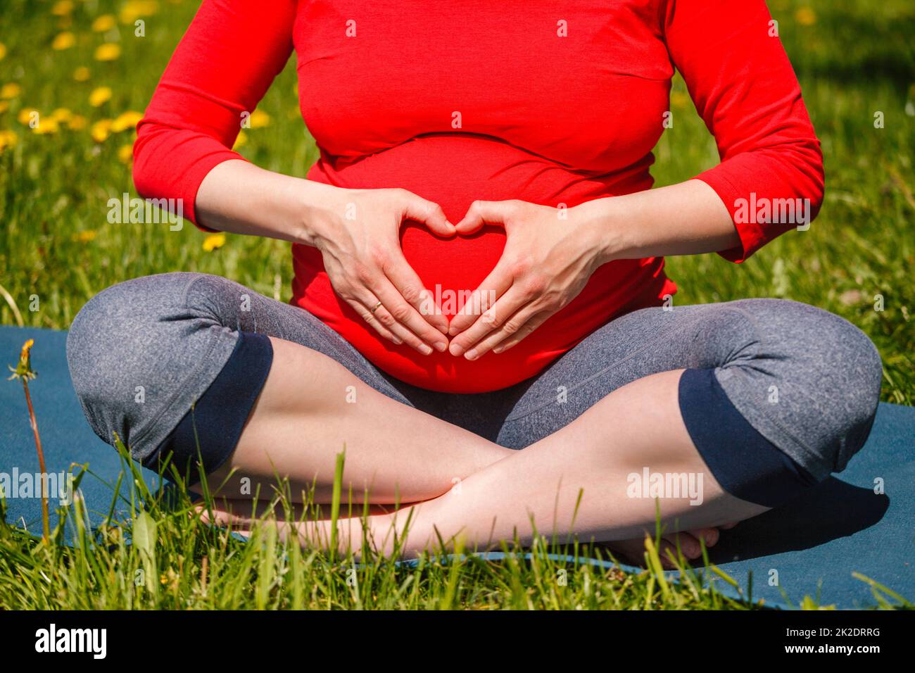 Schwangere, die im Freien Asana Sukhasana macht Stockfoto