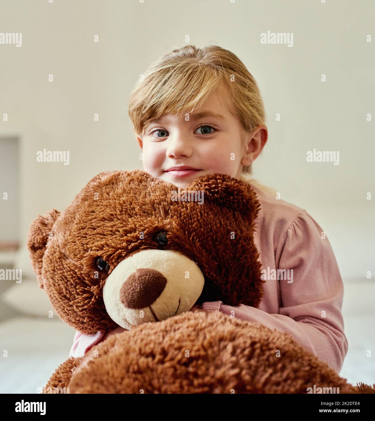 Ich weiß, dass Teddy niedlich ist, aber ich denke, ich bin netter. Porträt eines kleinen Mädchens, das ihren Teddybären zu Hause hält. Stockfoto