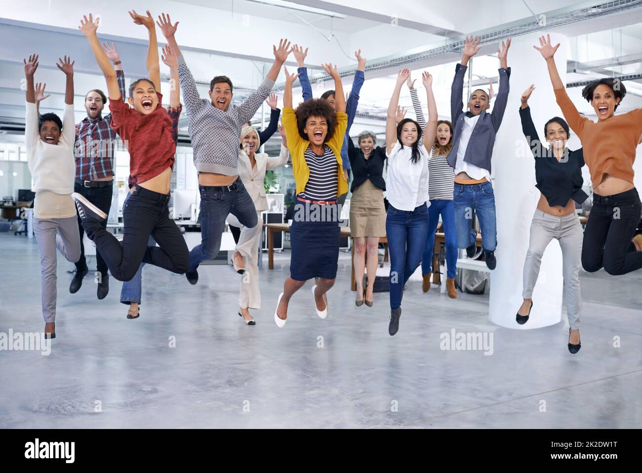 Sie springen bei der Chance, Ihnen zu helfen. Aufnahme von Büromitarbeitern, die springen. Stockfoto